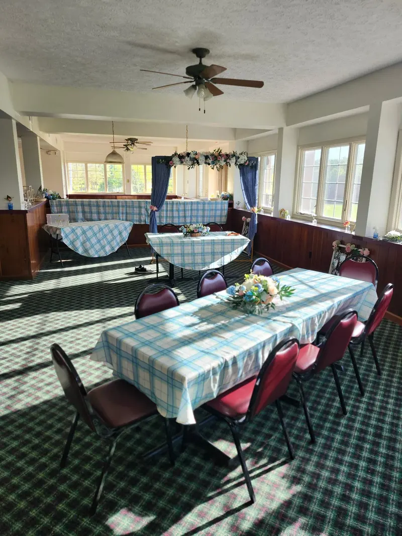 Bright reception room prepared with round tables and a decorated focal area