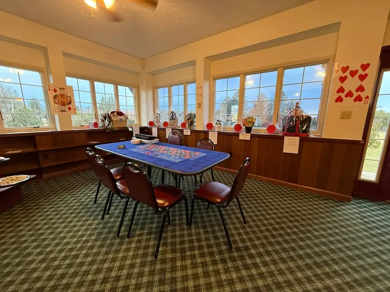 Card tables arranged by the windows for a themed birthday gathering