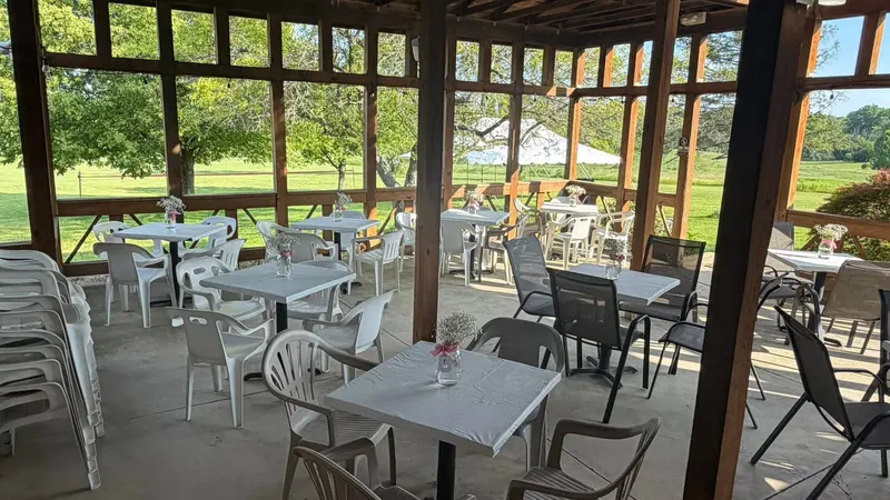 White patio tables and chairs on Chapel Hill Venue's covered outdoor terrace