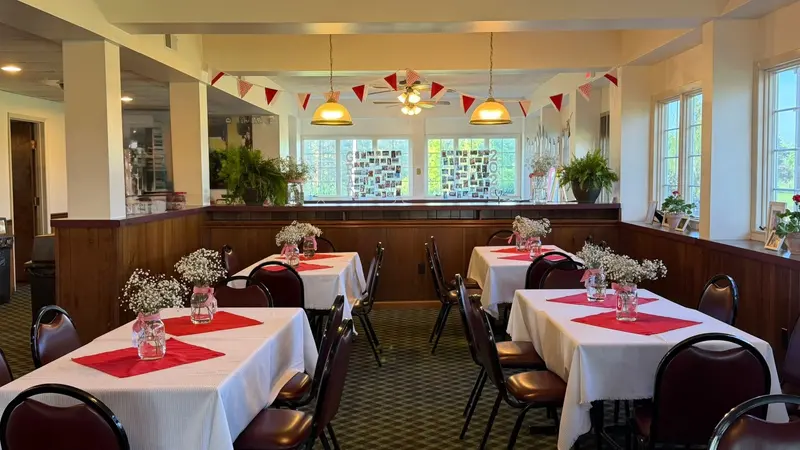 Guest tables with red linens in the venue's open dining room