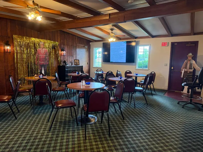 Round tables arranged in the wood-paneled fireside gathering room