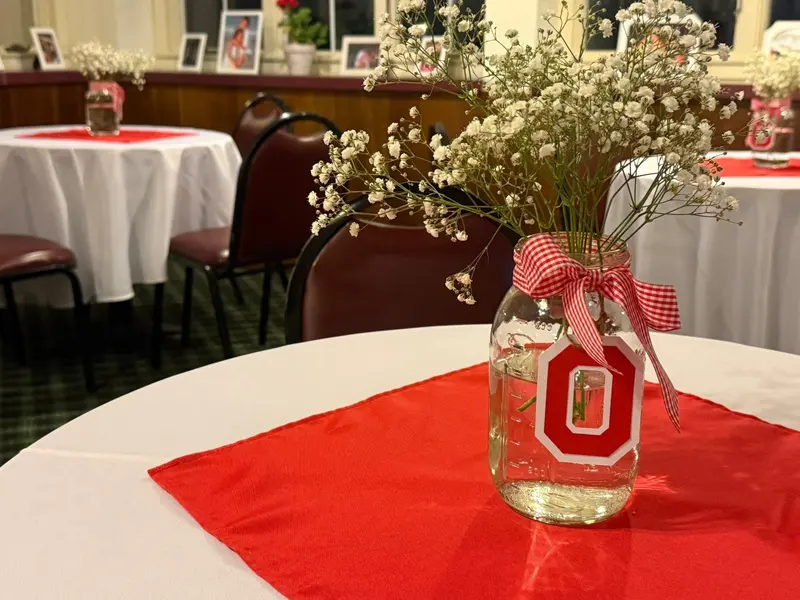 Floral graduation centerpiece on a red and white guest table
