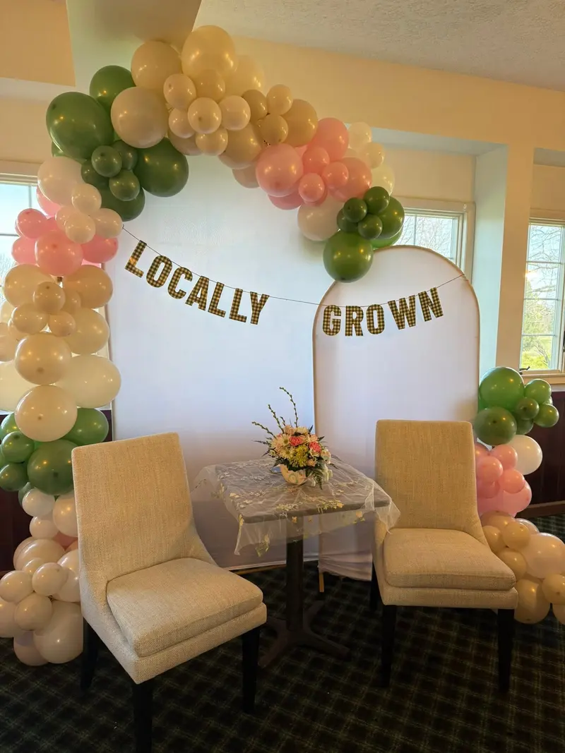 Green, gold, and cream balloon display for a family celebration
