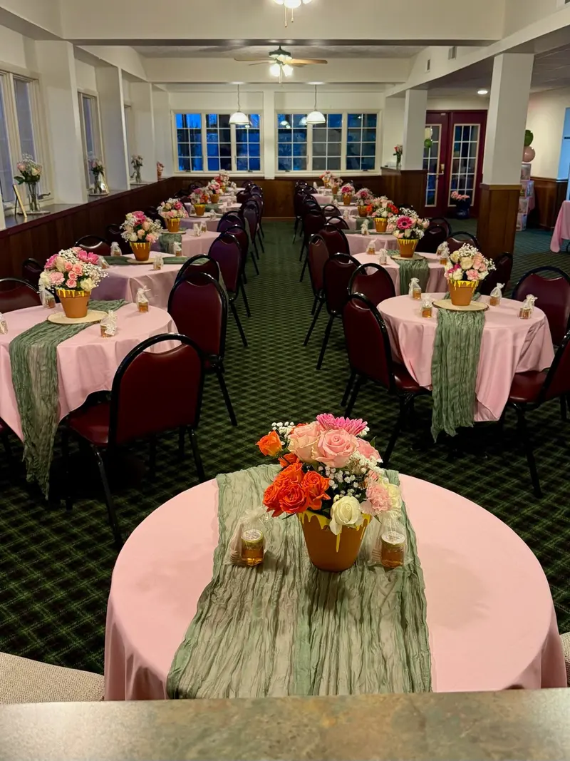 Pink and sage floral table settings arranged throughout the reception room