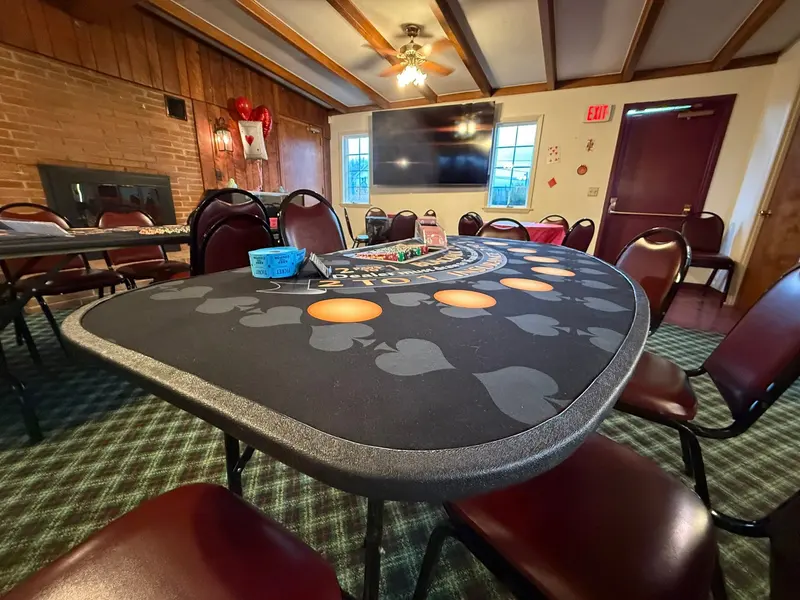 Poker table and seating arranged in the venue's wood-paneled room