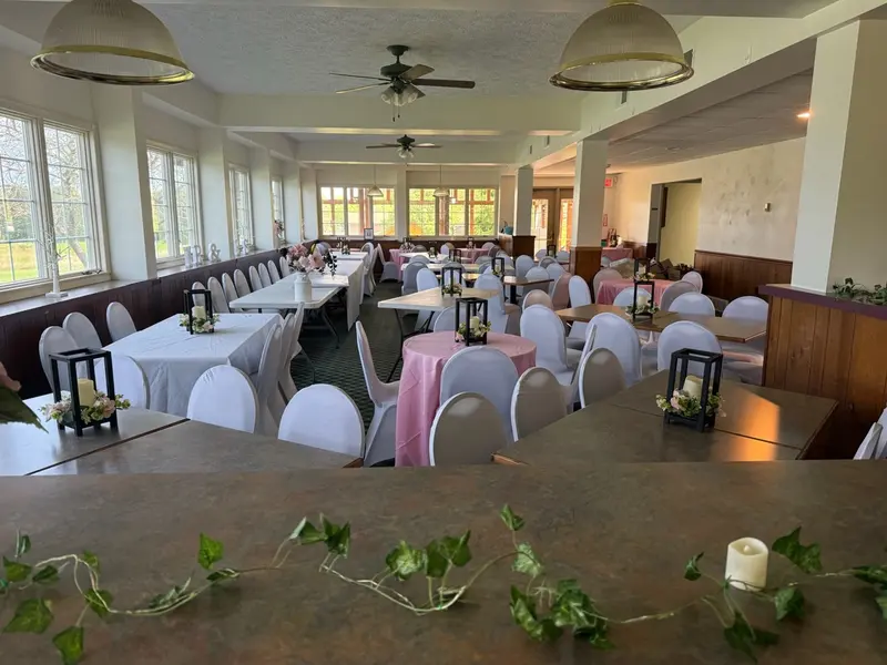 Sunlit reception room prepared with pink linens and lantern centerpieces