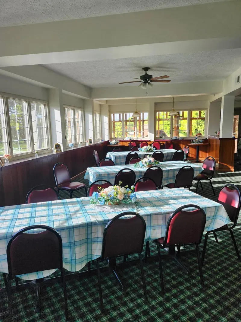 Window-lined sunroom arranged with blue place settings for a celebration