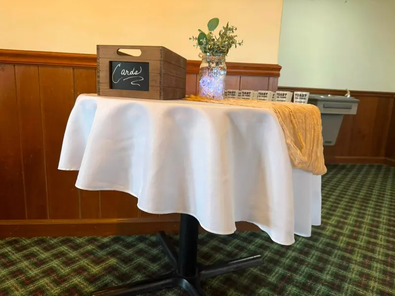 Simple welcome table with flowers and framed event signage