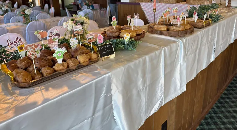 Woodland-themed dessert table with rustic signs and greenery